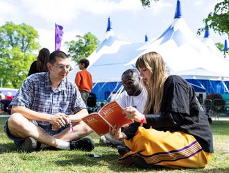 Three people looking at the Jazz Festival brochure