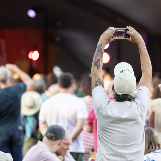 man taking picture of the free stage on his phone