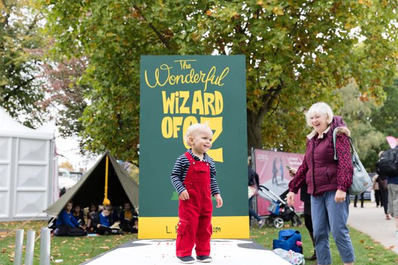 Child in front of The Wonderful Wizard of Oz sign