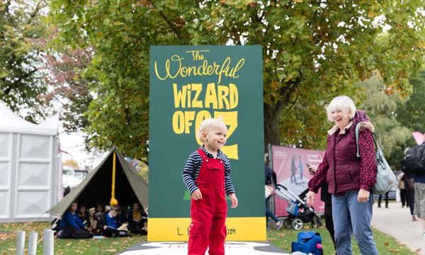 Child in front of The Wonderful Wizard of Oz sign