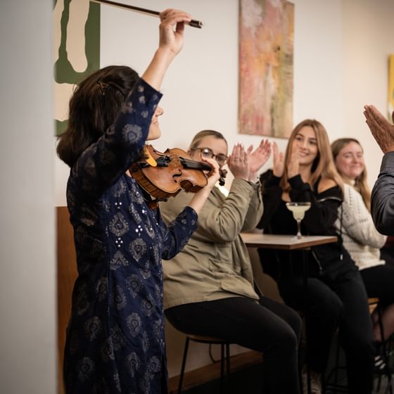 Violinist Rakhi Singh performing as a small crowd claps