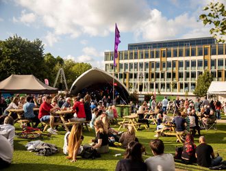 Crowds of people sat in front of the outdoor free stage at Cheltenham Music Festival 2021