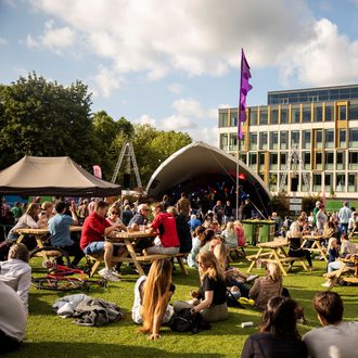 Crowds of people sat in front of the outdoor free stage at Cheltenham Music Festival 2021