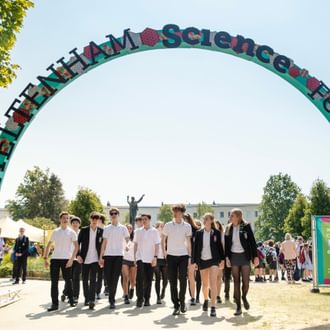 children in school uniform under an arch