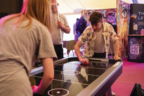 Two people playing air hockey