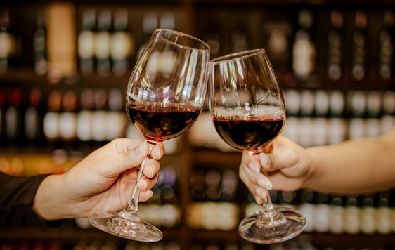 Two people cheersing glasses of wine