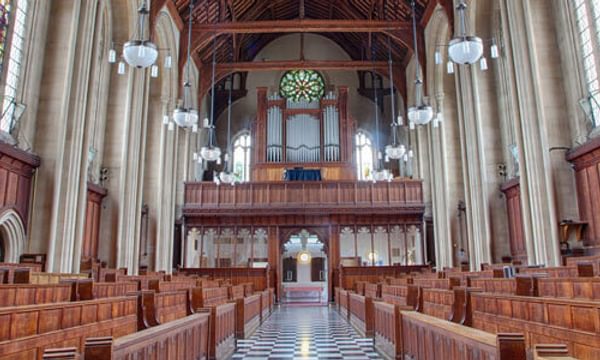 The interior of Francis Close Hall Chapel facing the organ through the pews