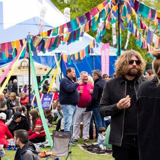 Festival-goers on site with tent and bunting