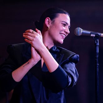 Nadine Shah performing on stage with mic