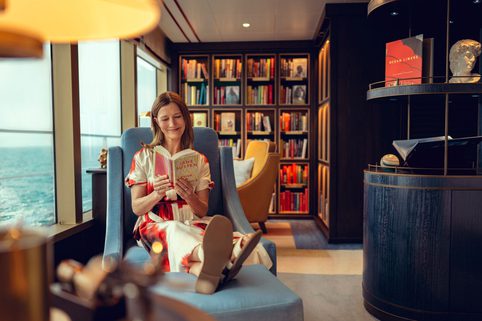 A woman reading a book in a library on board the Queen Anne