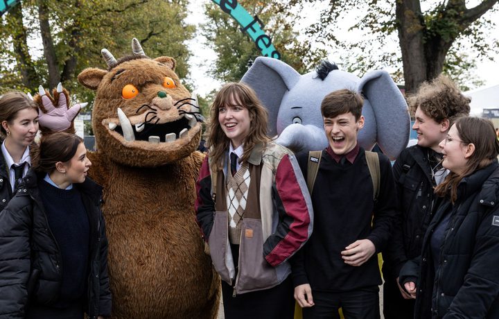 A group of secondary school children at Cheltenham Literature Festival with the Gruffalo in a character costume.