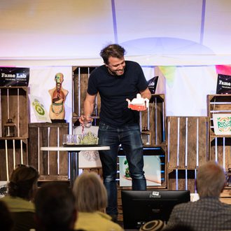 Participant on stage at FameLab International at Cheltenham Science Festival