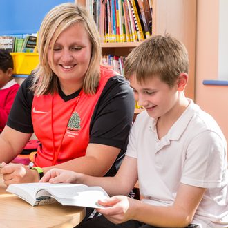 Teacher reading with pupil
