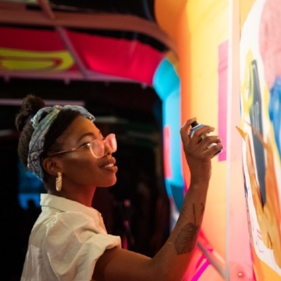 An artist spray painting at VOICEBOX