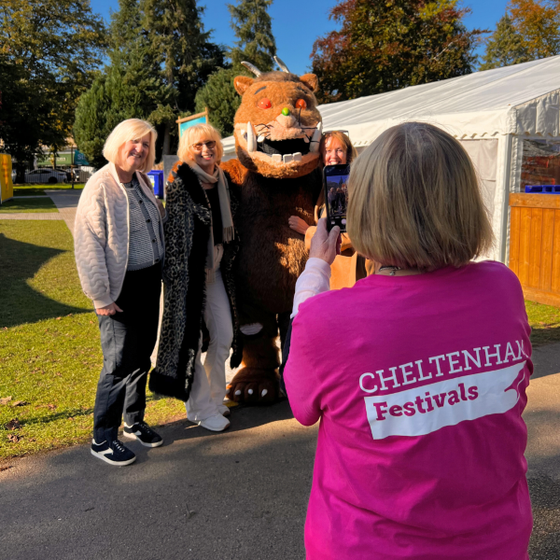Volunteer taking photo of festival-goers and Gruffalo character