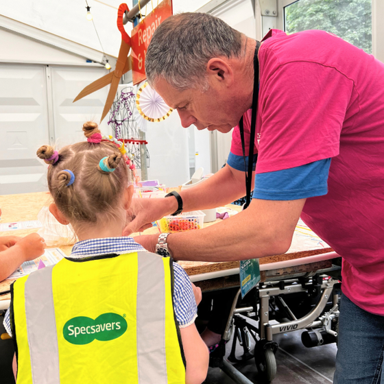 Volunteer helping child in Makershack