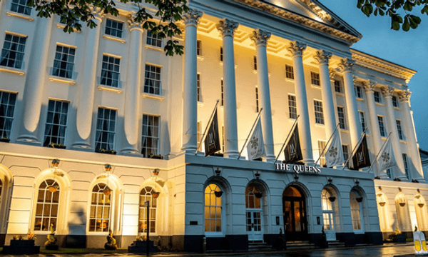 Regency hotel Queens at dusk, lit up with bright, yellow lights